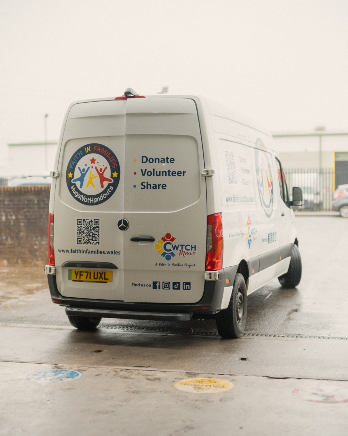 A white Faith in Families van with charity logos and messages to donate, volunteer, and share