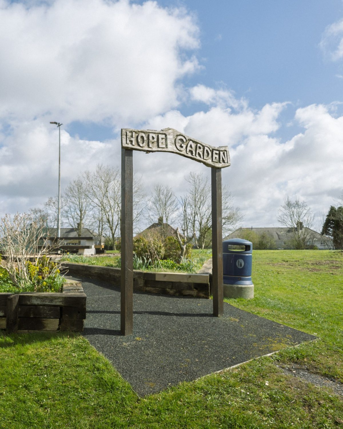 An archway in a field that has 'hope garden' engraved into it
