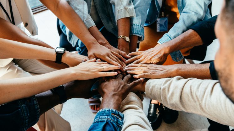 Teamwork concept with diverse hands joining together, symbolizing unity, cooperation, and collaboration stock photo