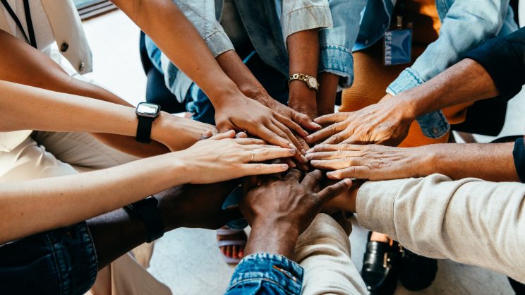 Teamwork concept with diverse hands joining together, symbolizing unity, cooperation, and collaboration stock photo
