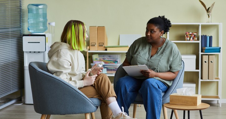 Woman talking to teenage girl at office