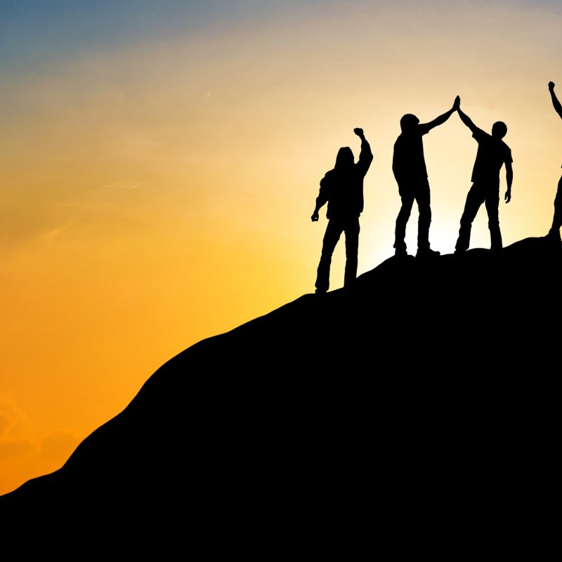 Group of people on peak mountain with sunset background ,team work success business winner concept
